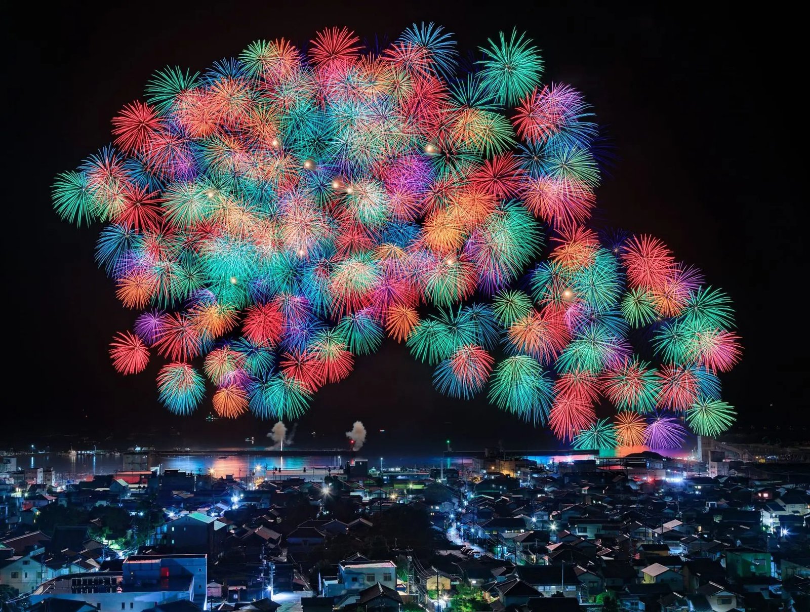 港町の夜空を埋める大輪